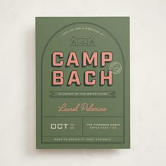 a green and pink camp bach poster on a white wall next to a black cat