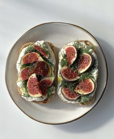 an open face sandwich with figs and cream cheese on toasted bread, sitting on a plate