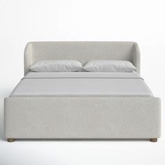 a bed with white sheets and pillows on it