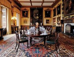 an ornate dining room with paintings on the walls and carpeted flooring, along with a table surrounded by chairs