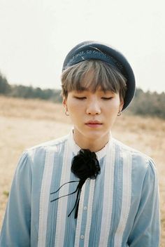 a young man with his eyes closed wearing a blue striped shirt and black bow tie