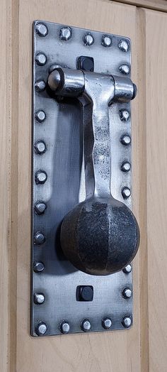 a door handle with a rock on it and rivets attached to the latch