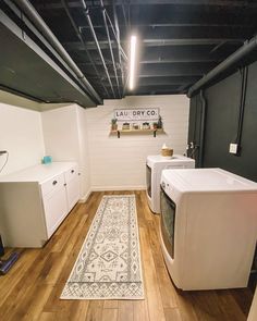 a washer and dryer in a room with wood flooring on the walls