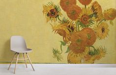 a yellow wall with sunflowers painted on it and a white chair in the foreground