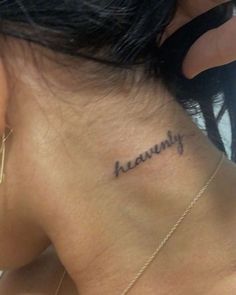 the back of a woman's neck with her name tattooed in cursive writing