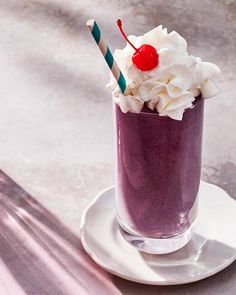 a purple drink with whipped cream and a cherry on top