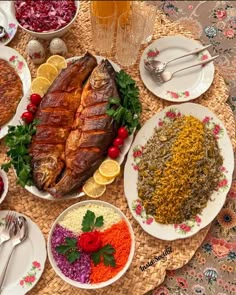 a table topped with plates and bowls filled with different types of food next to silverware