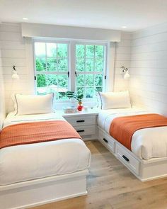 two beds in a room with white walls and wood floors