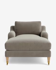 a gray couch with wooden legs and an arm rest in front of a white background