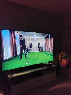 a man playing golf on the television screen