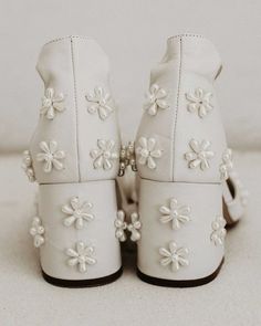 a pair of white shoes with flowers on them