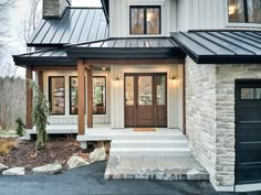 a house with a metal roof and stone steps leading up to the front door area