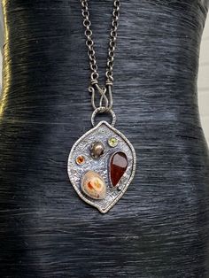 "Artisan Amber with Mexican Fire Opal pendant in sterling silver Hand-made Sterling Silver 925 Stones used: Baltic Amber, Mexican Fire Opal Purple Pearl, Peridot, Citrine Height - 2\", Width - 1 3/8\" Unique Handcrafted One-of a-kind Design Pendant Each Piece of Jewelry in my Collection is Absolutely One of a Kind! When you start wearing a piece of my jewelry you will fall in love with it more and more each day and feel that good Energy and Love that I pass into it while creating this piece of A Unique Teardrop Stone Jewelry, Hand Forged Amber Necklace As Gift, Unique Sterling Silver Gemstones For Gifts, Artisan Sterling Silver Pendant Necklace, Hand Forged Amber Necklace For Gift, Artisan Sterling Silver Necklace For Gift, Unique Sterling Silver Necklace With Large Pendant, Fusion Style Hand Forged Necklace As Gift, Custom Silver Pendant Necklace One Of A Kind