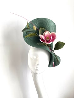 Bottle green magnolia fascinator Bottle green magnolia fascinator hat will be an amazing accessory to compliment your outfit. The fascinator will fit the average head size. Its made from silk covered headband attached to the green polybraid saucer base on which sits a pink magnolia flower and a pink feather. To secure your fascinator there is a comb inside the hat attached to the headband, so the fascinator sits very securely on your head. Enjoy your special day with this beautiful headpiece! ht Floral Fascinators Hair Pieces, Luxury Green Hat For Royal Ascot, Fresh Flower Fascinator, Green Mini Hat With Curved Brim For Wedding, Green Wide Brim Fascinator For Wedding, Green Wide Brim Mini Hats For Wedding, Kentucky Derby Green Fascinator With Handmade Flowers, Green Short Brim Headpiece For Kentucky Derby, Green Headpiece With Short Brim For Kentucky Derby