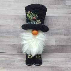 a black and white snowman wearing a top hat with fur on it's head