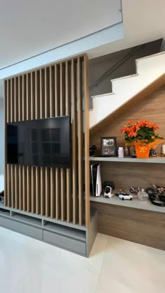 a living room filled with furniture and a flat screen tv on top of a wooden shelf