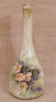 a vase with flowers painted on it sitting next to a white wall and tan background