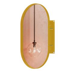 an oval mirror with a light bulb hanging from it's side and a yellow frame