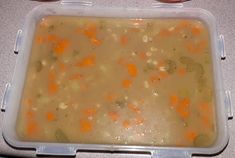 two plastic containers filled with soup on top of a table