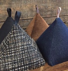 three different colored pillows sitting on top of a wooden table