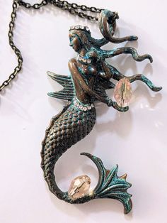 Large, highly detailed mermaid pendant necklaces (they're even prettier in-person). VERIFY YOUR OPTION(S) IN NOTES AT CHECKOUT   Option 1: Green patina mermaid with pink faux crystal beads, rhinestone belt, necklace, and crown, 20-inch chain Option 2: Silver mermaid with faux pearl beads, rhinestone belt, necklace, and crown, 20-inch chain Option 3: Swimming mermaid with rhinestone bra and belt, 18-inch chain Swimming Mermaid, Belt Necklace, Mermaid Pendant Necklace, Rhinestone Bra, Mermaid Pendant, Silver Mermaid, Rhinestone Belt, Pearl Beads, Crystal Beads