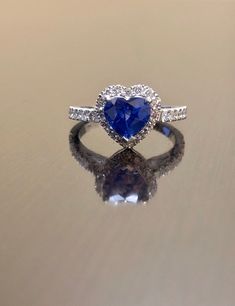 DeKara Designs Clearance A Beautiful Entirely Handmade Unique 18K White Gold Heart Shape Ceylon Blue Sapphire Halo Diamond Engagement Ring. Metal- 18K White Gold, .750. Modern, Three Prong Set, Pave Set, White Gold Ring. Stones- 1 Genuine Heart Shape Ceylon Blue Sapphire 1.80-1.95 Carats. 33 Round Diamonds, H Color VS2-SI1 Clarity, 0.65 Carats. The Height of the ring is 8 MM, the Halo Including the Diamonds Has Measurements of 11 x 10.30 MM. Beautiful and Timeless Halo Diamond Halo Heart Shape B Sapphire Heart Cut Jewelry With Brilliant Cut, Blue Cubic Zirconia Anniversary Rings, Blue Sapphire Diamond Ring With Heart Cut, Luxury Sapphire Heart Cut Jewelry, Blue Diamond Heart Ring For Wedding, Heart-shaped Sapphire Jewelry With Brilliant Cut, Sapphire Heart Cut Jewelry With Brilliant Detail, Heart-cut Sapphire Jewelry With Brilliant Cut, Heart Cut Sapphire Jewelry With Brilliant Cut