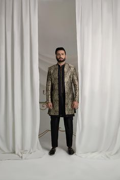 Upgrade your style with our Black and Gold Prince Coat. Made from luxurious brocade material, this front open coat exudes royalty. Paired with an Indian raw silk kurta pajama, it's the perfect ensemble for any formal event. Elevate your look and make a statement with this unique and elegant piece. 3-Piece Suit Designer Long Sleeve Sherwani For Formal Occasions, Formal Long Sleeve Bandhgala With Naqshi, Designer Long Sleeve Kurta For Formal Occasions, Gold Embroidered Straight Kurta Bandhgala, Designer Bandhgala With Gold Embroidery Straight Kurta, Designer Nehru Jacket Straight Kurta For Festive Occasions, Designer Long Sleeve Suits For Festive Occasions, Festive Brocade Sherwani With Naqshi Detailing, Elegant Traditional Drape Outerwear For Party