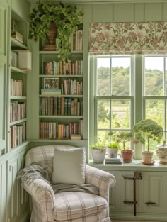 a chair sitting in front of a window next to a book shelf filled with books