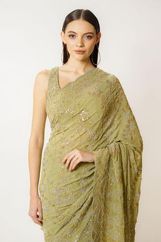 Olive green georgette saree featuring hand embroidered sequins and cutdana work. Paired with a sleeveless blouse with a round neckline and back hooks and tie-up closure., Fit: Relaxed Pista Green Sequined Dupatta In Traditional Drape, Green Cutdana Pre-draped Saree For Evening, Georgette Pre-draped Saree With Sequins For Reception, Reception Georgette Pre-draped Saree With Sequins, Green Georgette Pre-draped Saree With Traditional Drape, Green Georgette Pre-draped Saree, Sleeveless Georgette Pre-draped Saree For Party, Green Sequined Saree For Festive Occasions, Sleeveless Party Wear Pre-draped Georgette Saree