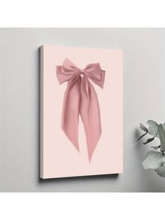 a pink bow is hanging on the wall next to a potted plant and vase