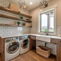 a washer and dryer in a kitchen with open shelving on the wall