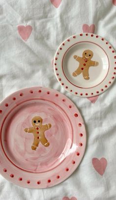 two pink and white plates with ginger cookies on them, one has a heart - shaped design