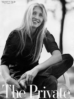 a woman sitting on top of a wooden bench