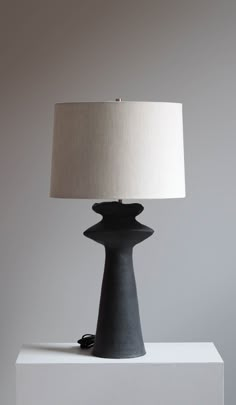 a table lamp sitting on top of a white block