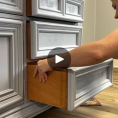 a woman is opening the drawers in her kitchen