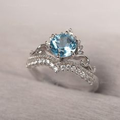 a blue topazte and diamond ring on a white surface