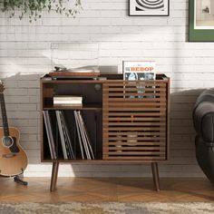 a record player sitting next to a wall with a guitar and other records on it