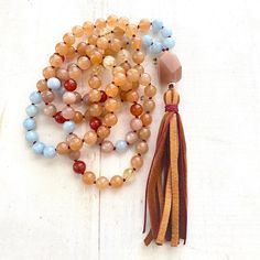 "A wonderful Mala for helping with insecurities. Handcrafted with Aquamarine for support when feeling overwhelmed and Peach Aventurine for assistance when making decisions. This Mala also consists of Sunstone which is known as a stone of leadership and personal power along with Carnelian to calm temper and give a sense of humor. An accent stone of Citrine is worked in for joy and happiness. All these healing stones are hand knotted into this beautiful 108 bead Mala. Charm not included, please se Spiritual Hand-strung Amber Beaded Necklaces, Amber Beaded Necklace For Meditation, Carnelian Beaded Crystal Necklaces For Healing, Spiritual Carnelian Beads For Jewelry Making, Orange Spiritual Beaded Necklace With Natural Stones, Spiritual Orange Beaded Necklace With Natural Stones, Spiritual Amber Crystal Necklaces With Round Beads, Brown Natural Stones Mala As A Gift, Orange Beaded Necklaces With Natural Stones In Spiritual Style