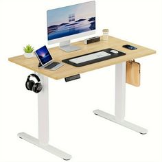 a computer desk with a laptop and headphones on it