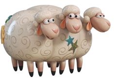 three ceramic sheep standing next to each other on top of a white surface with blue stars