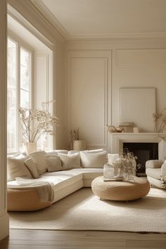 a living room filled with white furniture next to a fire place in a fireplace mantel