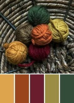 a basket filled with balls of yarn next to a knitting needle and color swatches