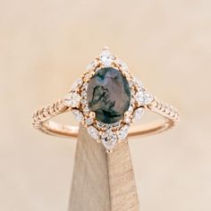 a diamond and blue stone ring on top of a wooden stand