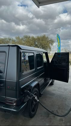 a mercedes benz is parked at a gas station with the door open and no fuel