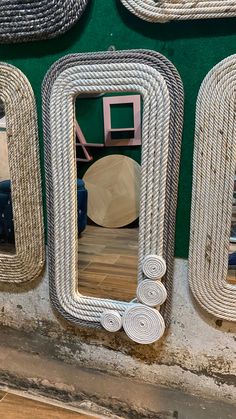 there is a mirror on the wall with rope around it and other mirrors behind it