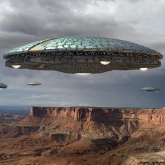 an alien ship flying over a canyon in the sky