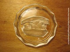 an etched glass plate with a boat in the water on it's side,