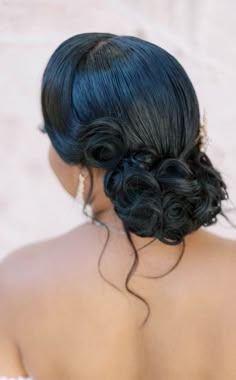 the back of a woman's head with blue hair and pearls in her hair