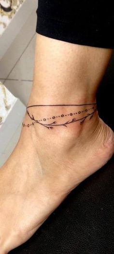 a woman's foot with a small tattoo on the side of her leg and an arrow