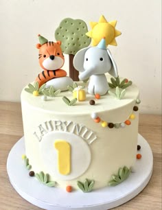 a birthday cake decorated with animals and trees